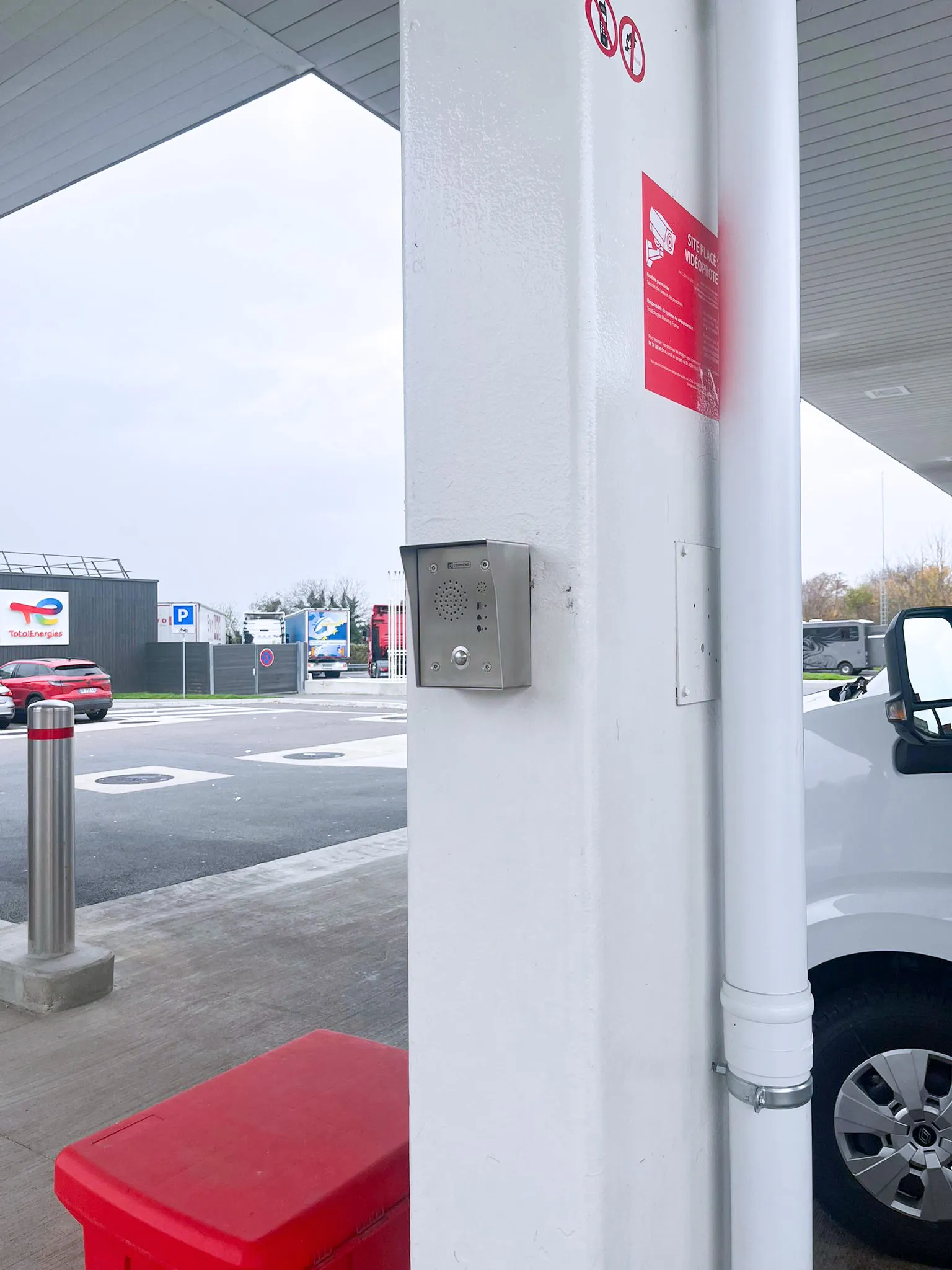 A silver intercom unit on a white pillar at a service area, serving as a key communication and security solution.