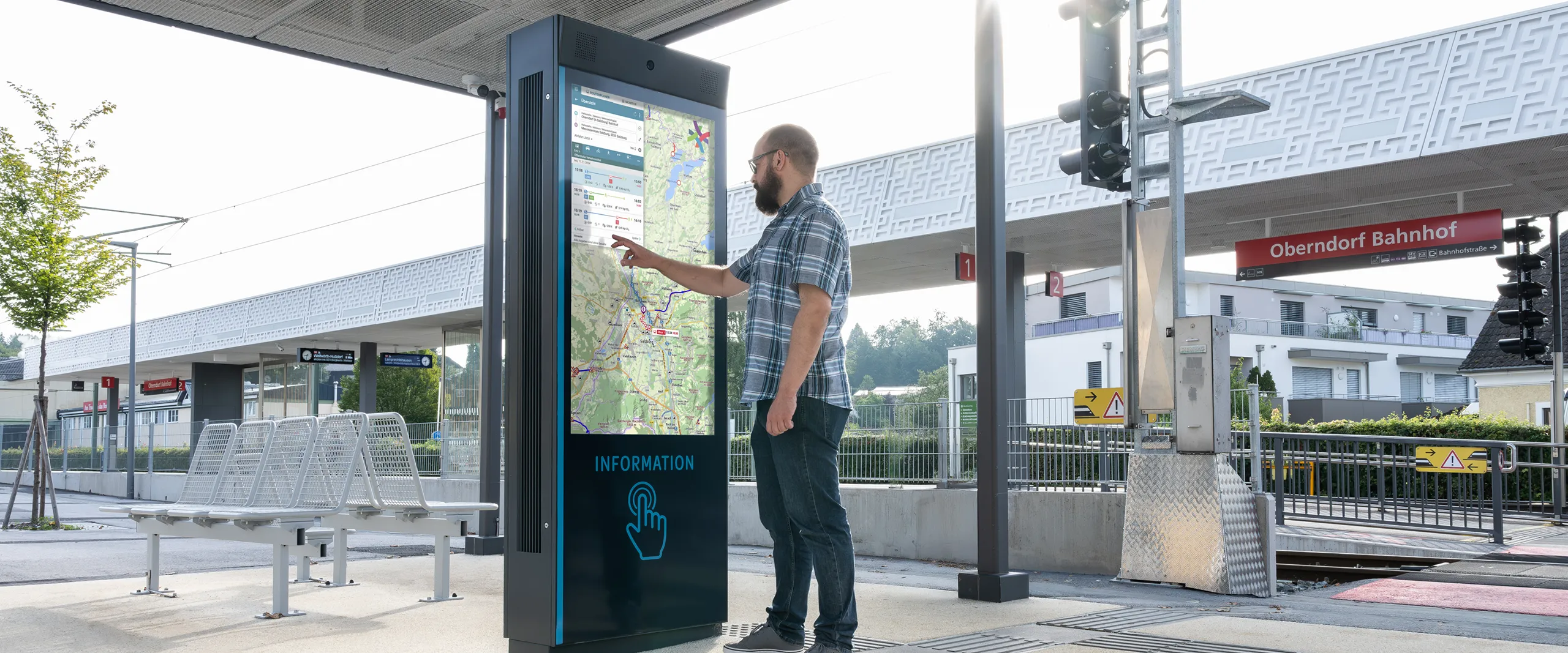 Passenger using digital intercom terminal at railway station for information