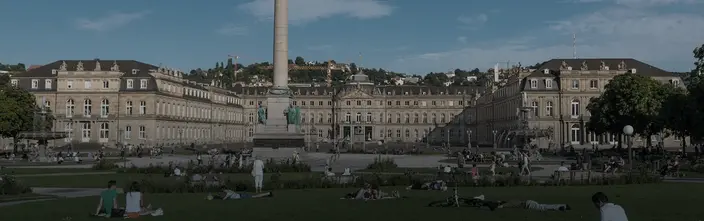 Schlossplatz a Stoccarda in una giornata di sole Vista panoramica della Schlossplatz di Stoccarda con il Nuovo Palazzo, Königsbau, colonna e persone nel parco.