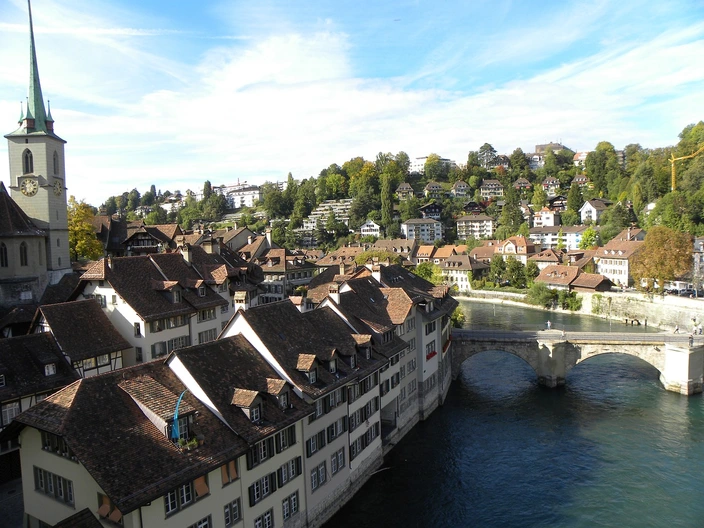 Bern Old Town, Aare River, Switzerland Panoramic view of Bern Old Town, Switzerland, with river, arched bridge, church, and houses on hills.