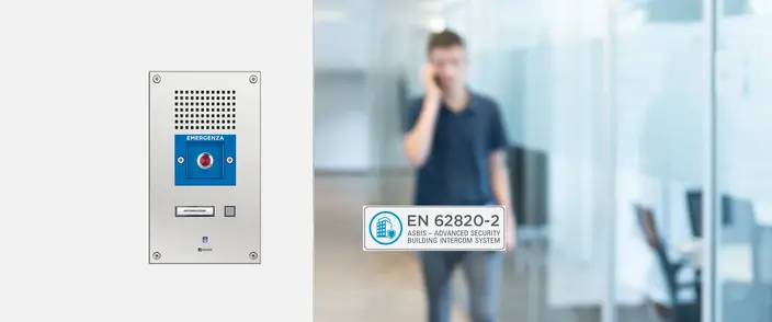 Edelstahl-Sprechanlage mit Notruf-Taste und EN 62820-2 Zertifikat an Glaswand.