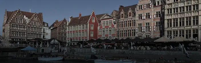 Scena del Canale Storico di Gand Edifici storici, caffè all'aperto e barche lungo un canale a Gand.