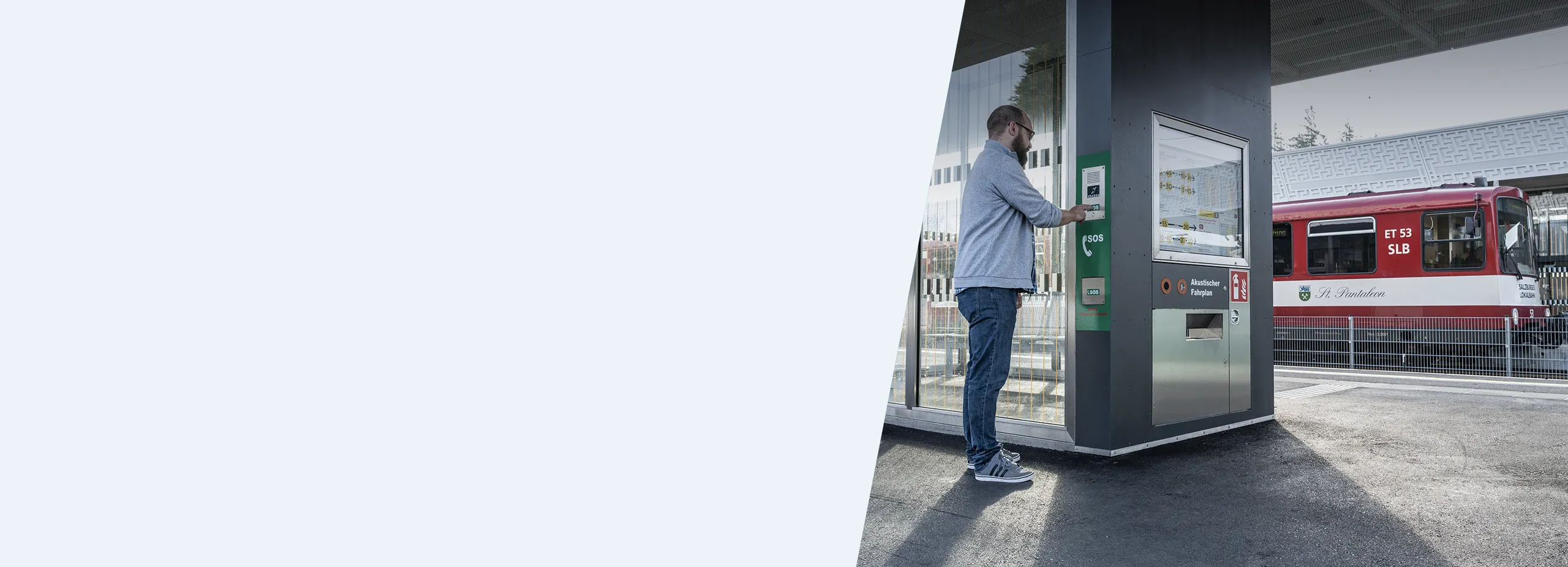 Passenger using intercom terminal at train station for assistance
