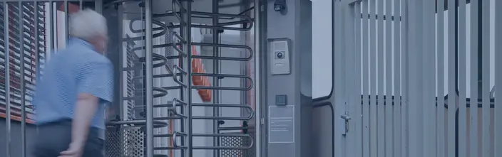 Accesso Sicuro con Interfonico Persona che passa attraverso un tornello con un interfonico per accesso sicuro.