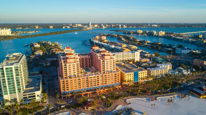 Küstenresort bei Sonnenuntergang Luftaufnahme des Don CeSar Hotels in St. Pete Beach, Florida, mit Strand und blauem Wasser.