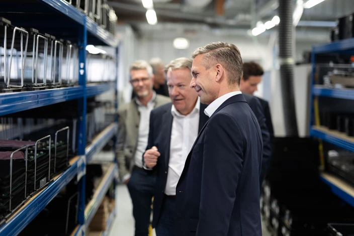 Inspection de nos interphones Hommes inspectant des postes d'interphonie sur des étagères bleues dans une usine.