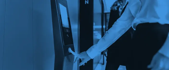 Modern Intercom System in Use Hand pressing button on modern blue intercom panel with screen.