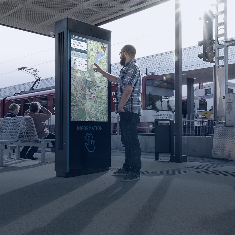 Commuter using digital help point at train station to access travel and safety information
