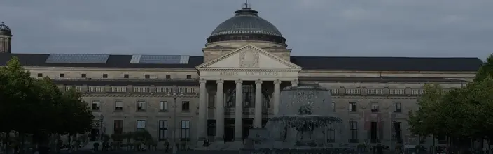Grandioso Kurhaus con Fontana Grandioso edificio classico con cupola, colonne, scritta "AQUIS MATTIACIS" e una grande fontana.