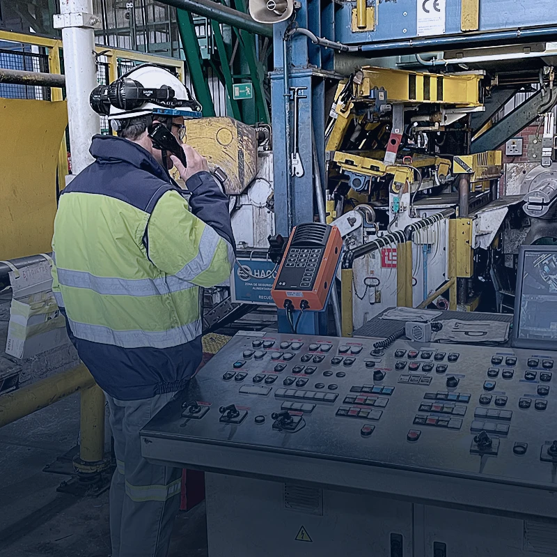 Worker using industrial intercom for reliable communication in manufacturing facility