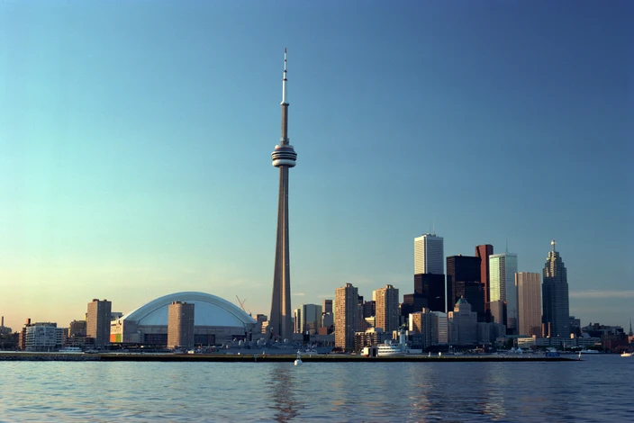 Toronto Skyline with CN Tower Toronto cityscape featuring the CN Tower, Rogers Centre, and high-rises by Lake Ontario.
